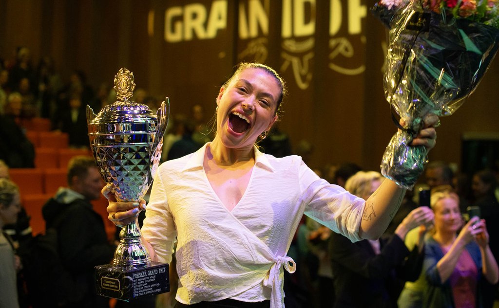 kvinne som feirer med pokal og bukett