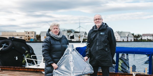 

kvinne og mann holder frem en pyramide