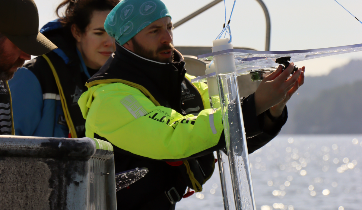 
Man in boat holding a transparent chamber