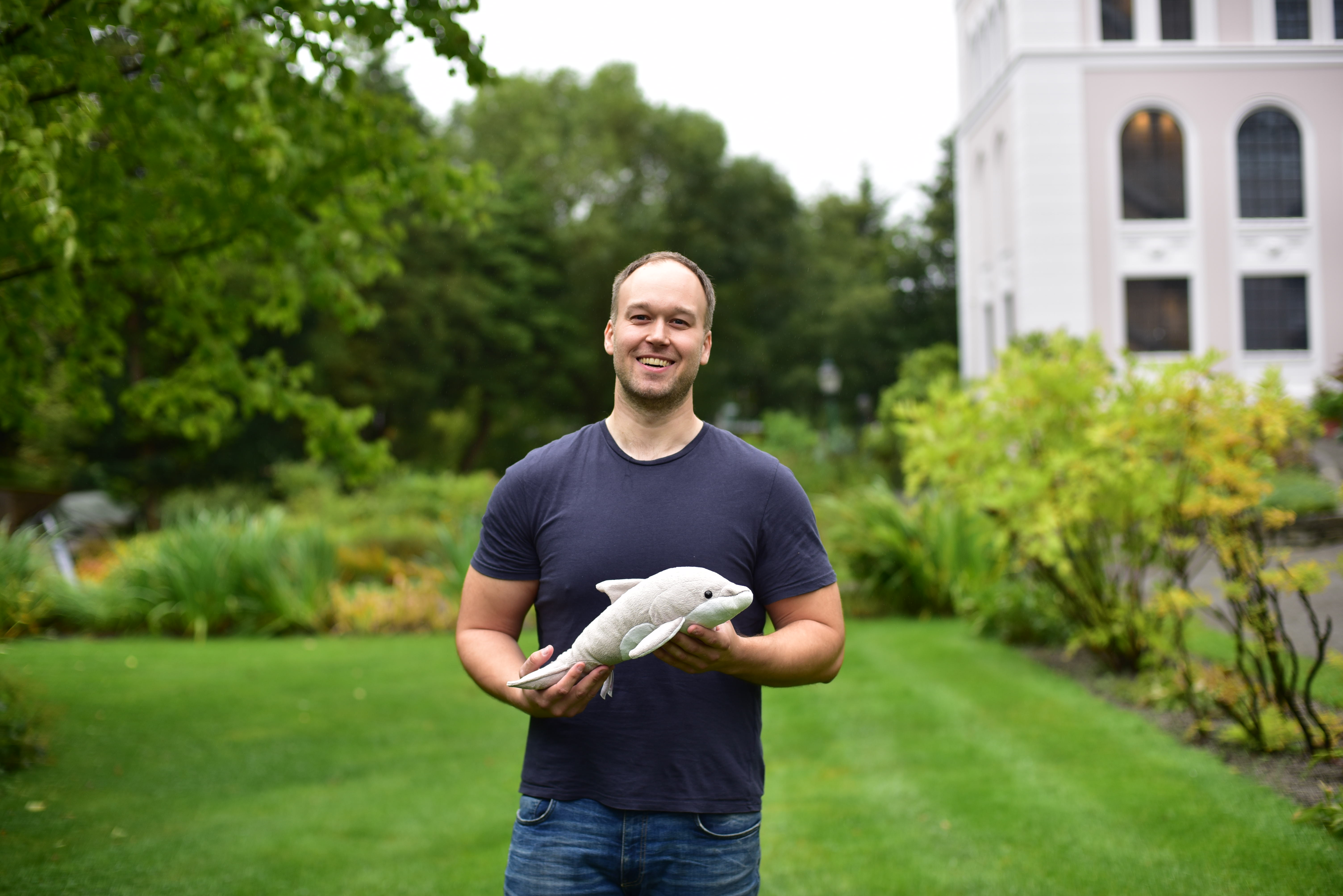 mann i park med spekkhoggerbamse i hendene