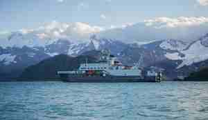 Kronprins Haakon med de mektige fjellene på Sør-Shetlandsøyene i bakgrunnen.