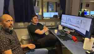 foto av to menn foran dataskjermer med ekkoloddbilder på