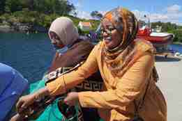 To kvinnelige prosjektdeltagere fra Sudan haler hummerteine i Arendal