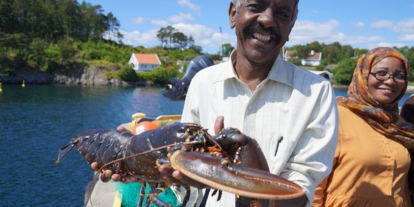 

Forsker Even Moland holder stor hannhummer i sollyset foran tre prosjektdeltakere fra Sudan.