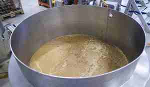 brunn suppe av blåskjell som skal brukes til laksefôr i en metal kar