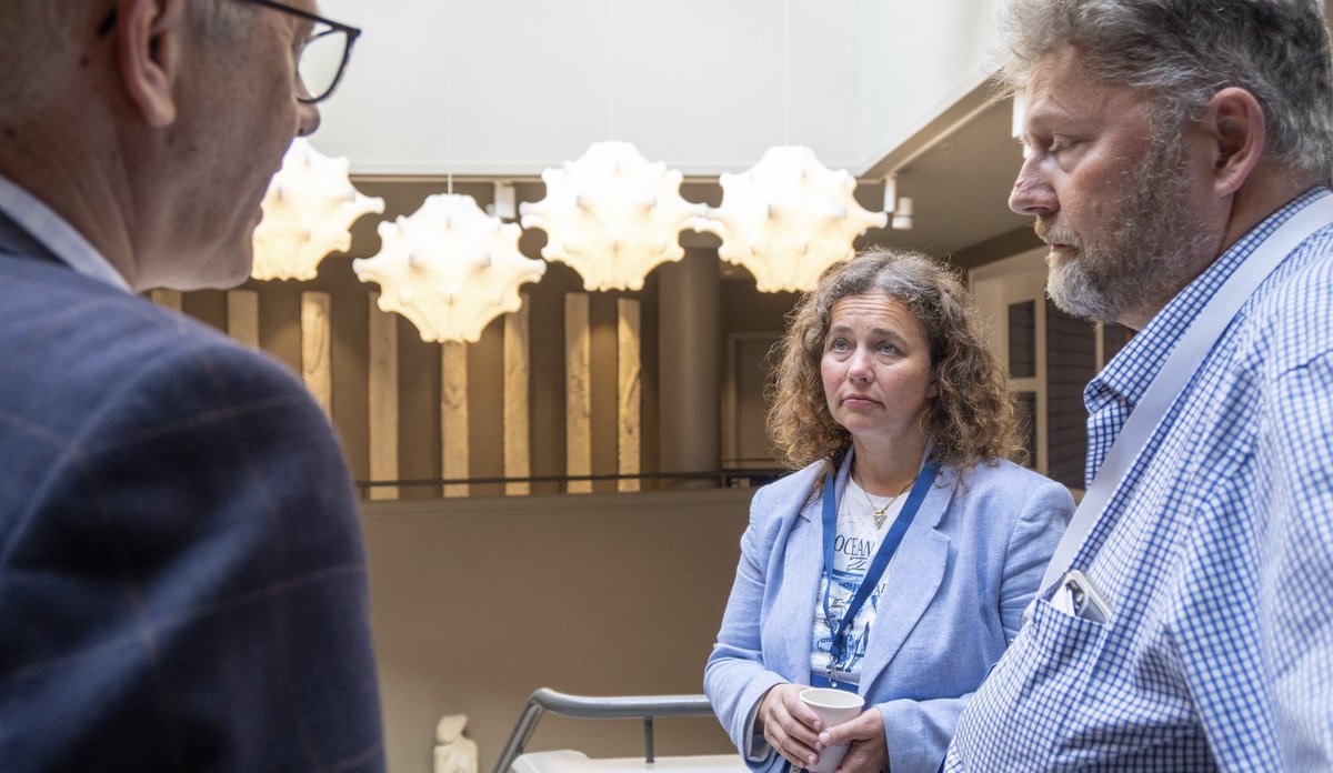 To menn og en kvinne slår av en prat