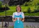 Kvinne med turkis kjole holder papir-versjon av en hoppekreps
