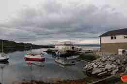 Feltstasjon i Finnmark, nokre små hus og båtar ved kaien.