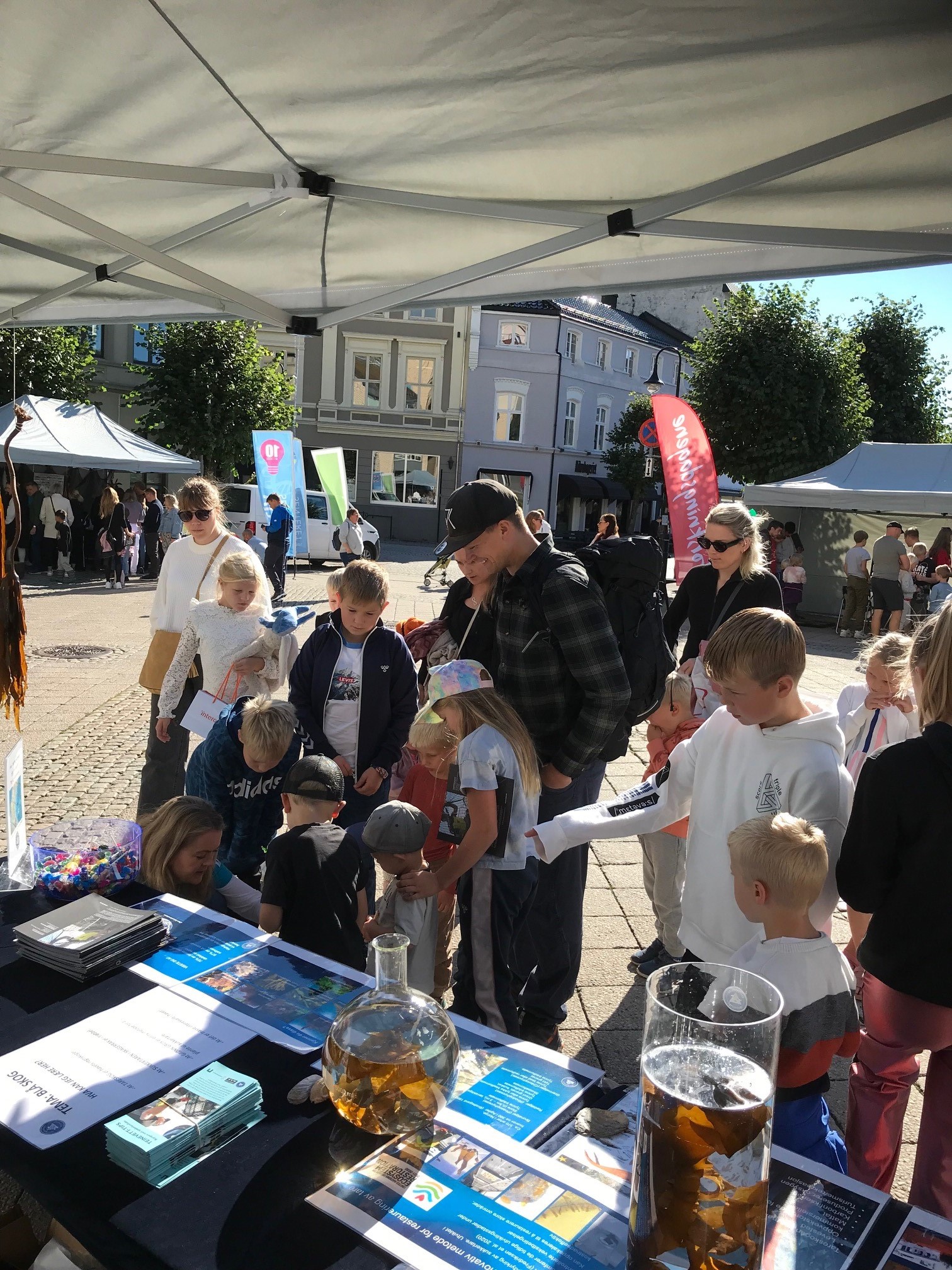Barn snakker med forskere på stand.