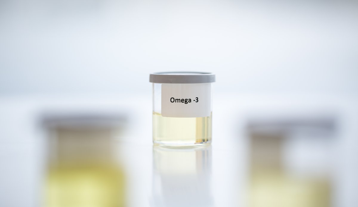 
Et lite glass med lysegul veske og påklistret lapp der det står «Omega-3.»