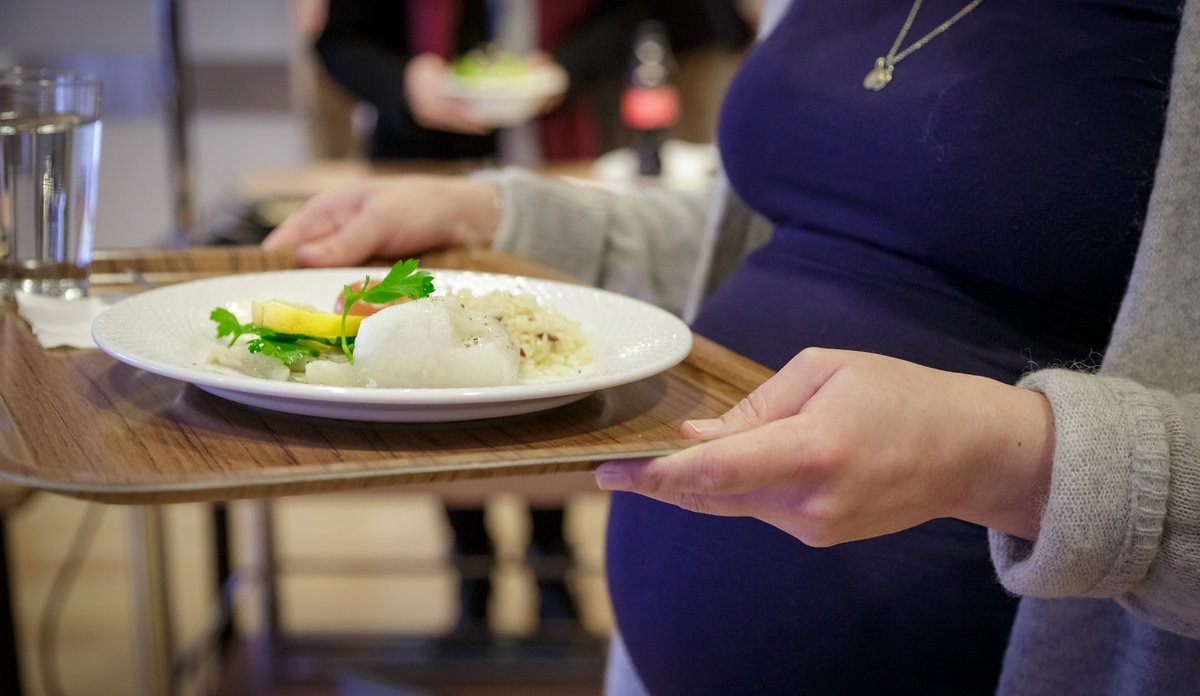 
gravid kvinne bærer tallerken med fisk