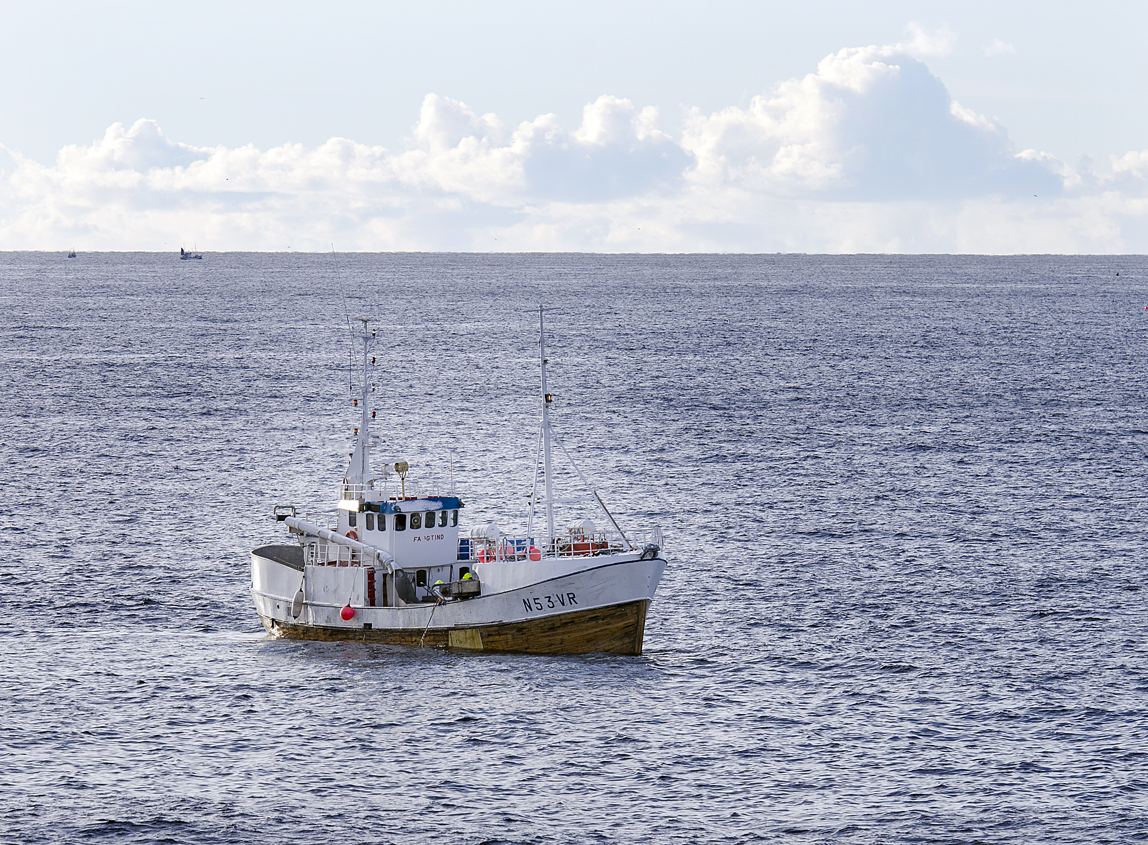 liten sjark på havet med snøkledde fjell i horisonten