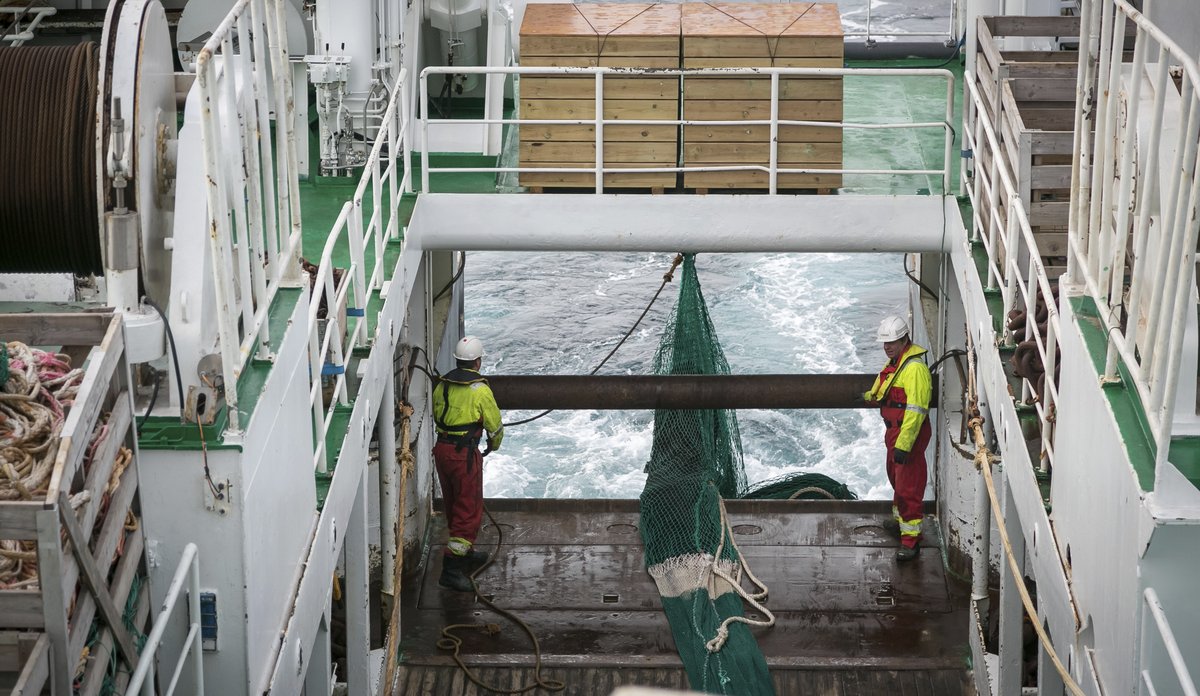 
Bilde fra et tråldekk, der to mannskap holder på å slippe ut trålen