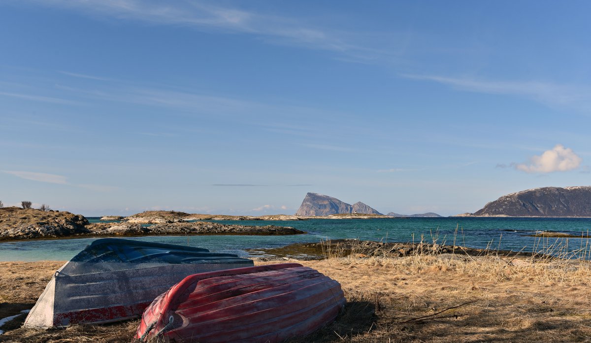 
To små båter som ligger opp ned i strandkanten 