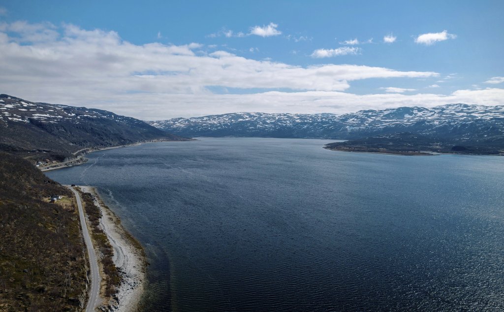 Dronefoto av fjord med fjell i bakgrunnen