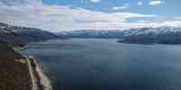 

Dronefoto av fjord med fjell i bakgrunnen