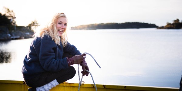 

Lene Christensen måler en hummer på taket til hummerteine som står på kaien.