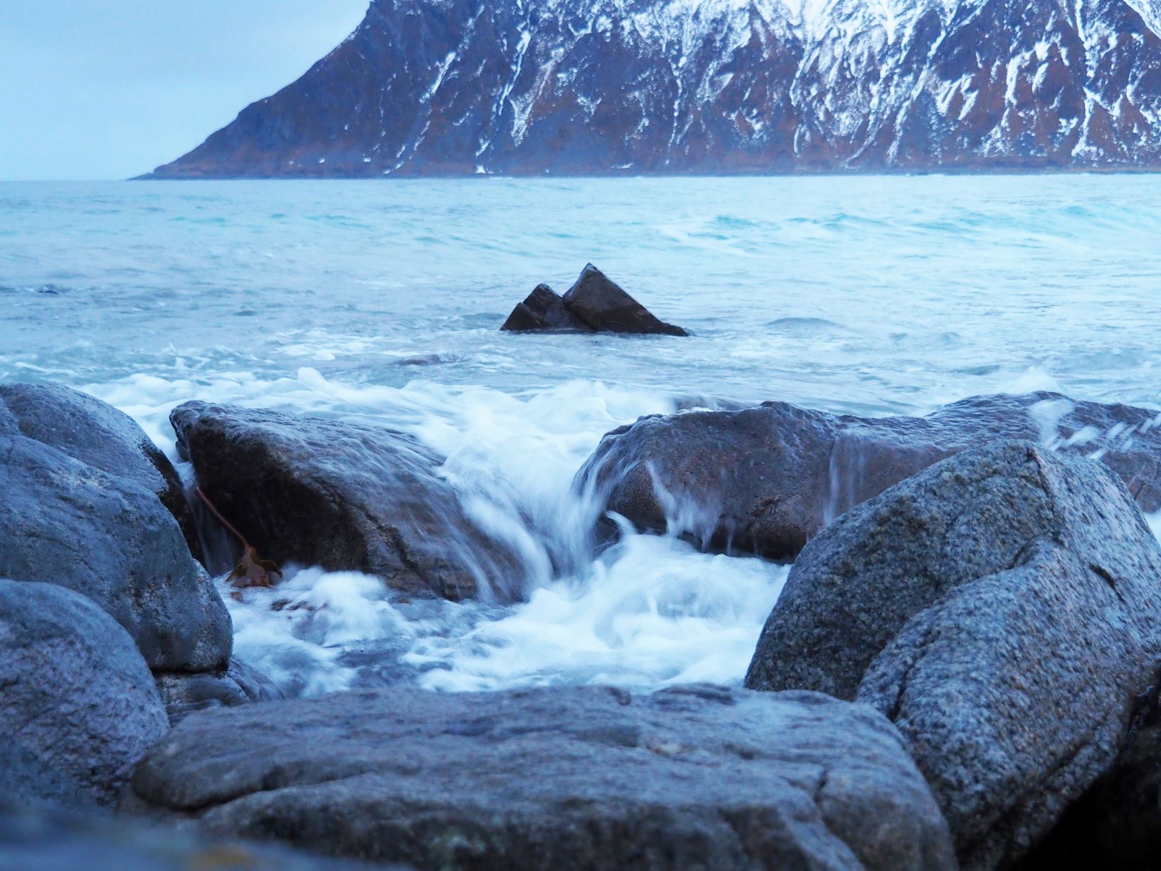 bølger slår over stein på strand
