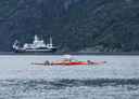 En kajakkdrone på fjorden med et forskningsfartøy i bakgrunnen