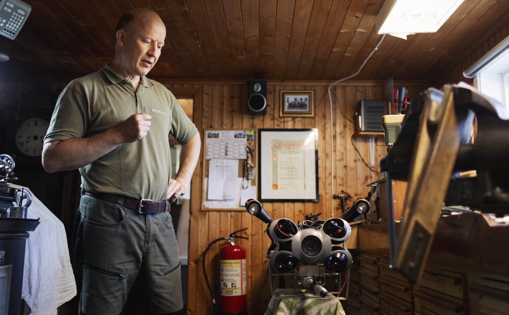 foto av mann på verksted med en slags robot på et bord