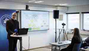 foto av mann ved podie og presentasjon