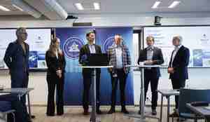 foto av en rekke personer bak et lite bord