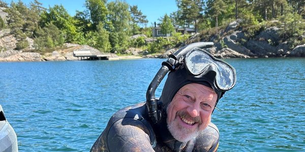 

Foto av en blid havforsker Stein Mortensen med sjø, svaberg og skog i bakgrunnen