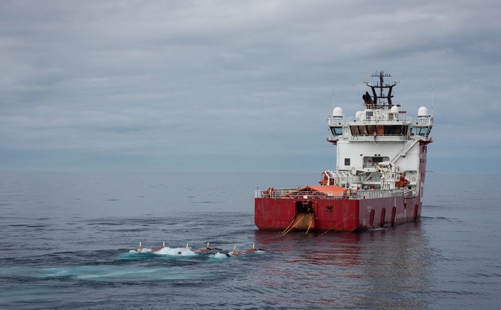 Foto av et seismikkskip med slep ute på havet