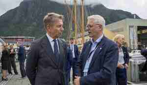 To menn i dress snakker sammen på en kai