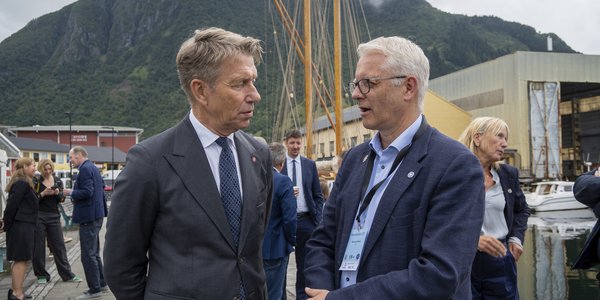 

To menn i dress snakker sammen på en kai
