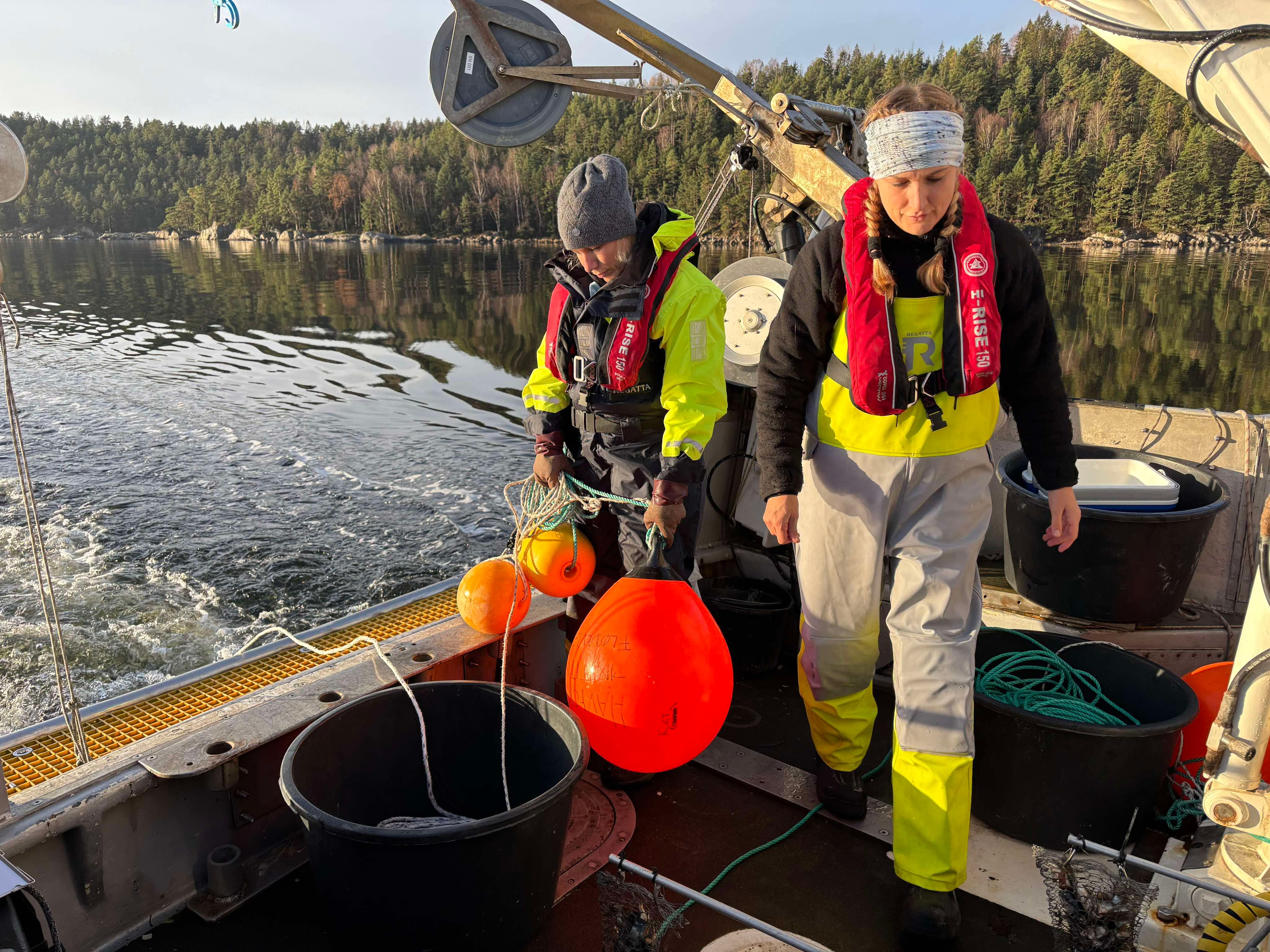 To kvinner står bak på en båt