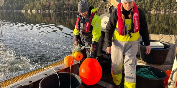 

To kvinner står bak på en båt