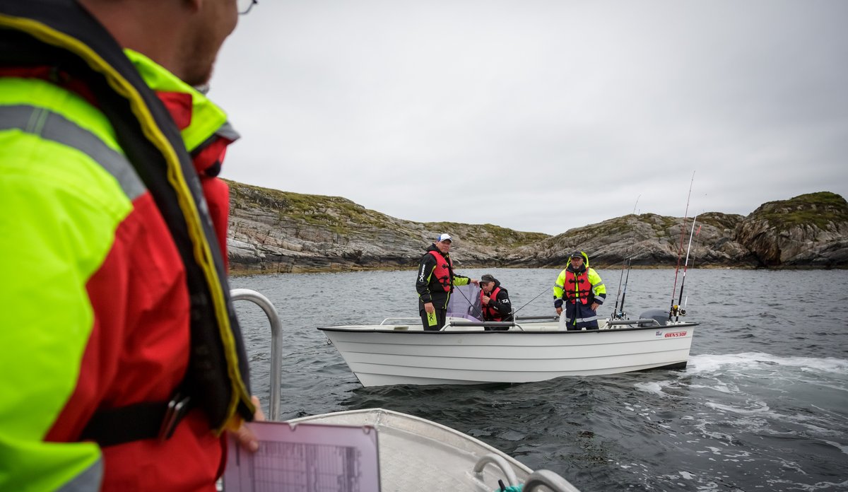 bilde av forsker i båt på sjøen som intervjuer fritidsfiskere