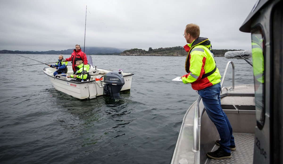 bilde av forsker i båt på sjøen som intervjuer fritidsfiskere