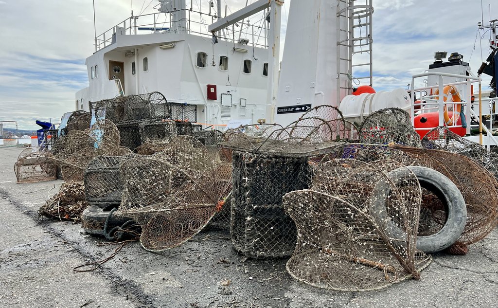 foto av båt bak stabel av opphentede spøkelsesteiner