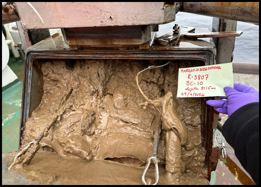 Box corer on the side with mud coming out of it