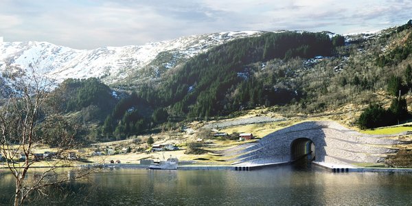 

tunnel i fjorden som går inn i en grønn bakke, med snøkledde fjell i bakgrunnen 