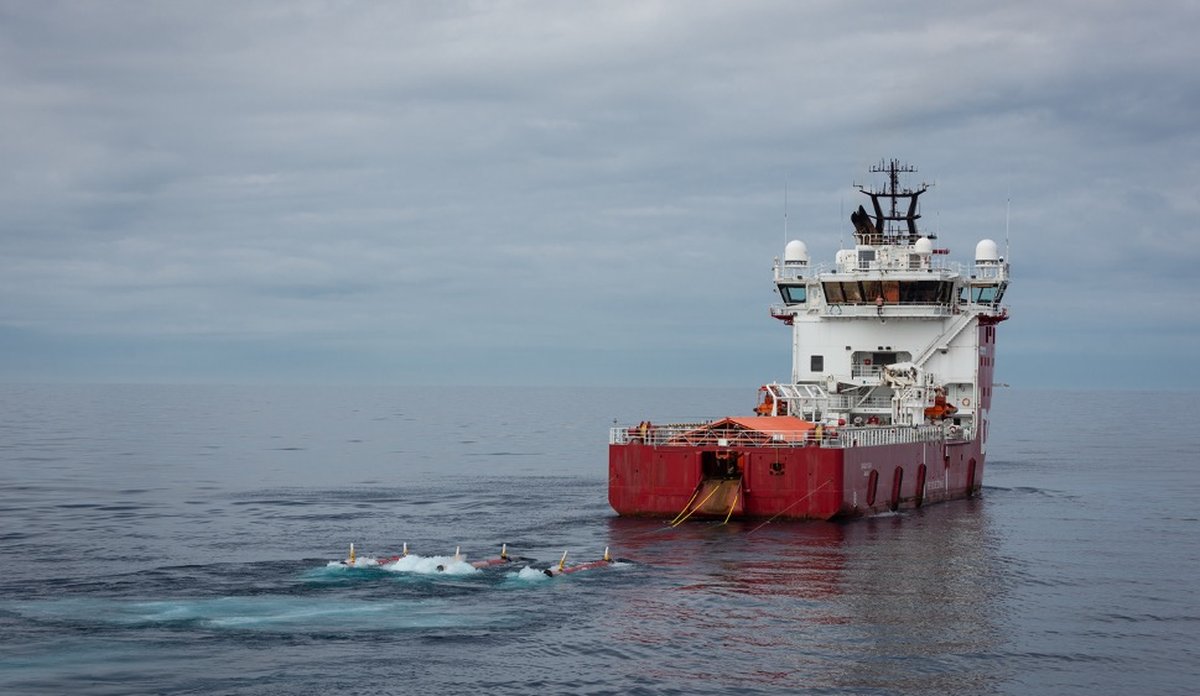 
foto av en supplybåt med torpedolignende gjenstander på slep i overflaten