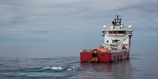 

foto av en supplybåt med torpedolignende gjenstander på slep i overflaten