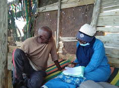 Man being interviewed by a women, sitting down.